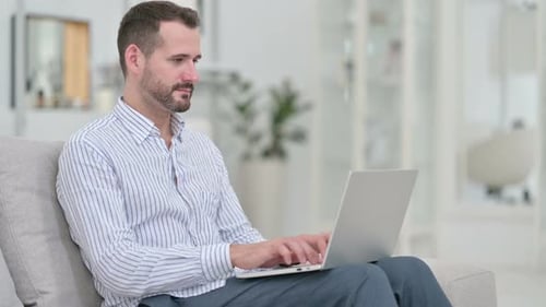 Man Working on Laptop Computer at Home