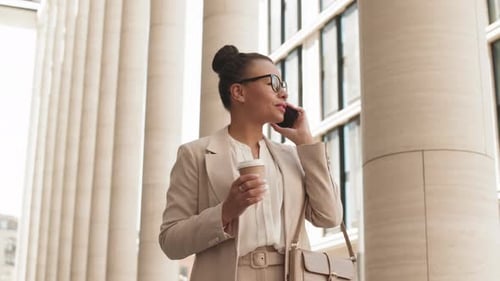 Contemporary Businesswoman Talking on Phone during Walk