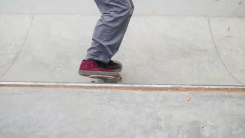 Skater Practicing in the Autumn Concrete Skate Park Making Tricks and Rides in Ramp