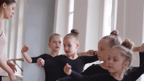 Woman Training Ballerinas in Ballet School