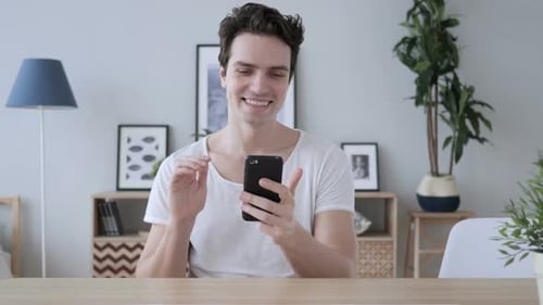 Man Smiling and Waving During Video Call