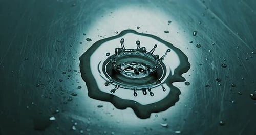 Water Droplets Impacting a Dark Blue Surface