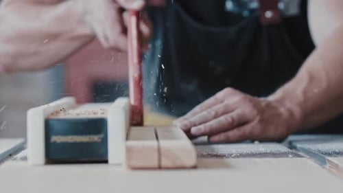 Carpentry Works Worker Cutting the Long Wooden Detail Using an Automatic Saw and Helping Himself
