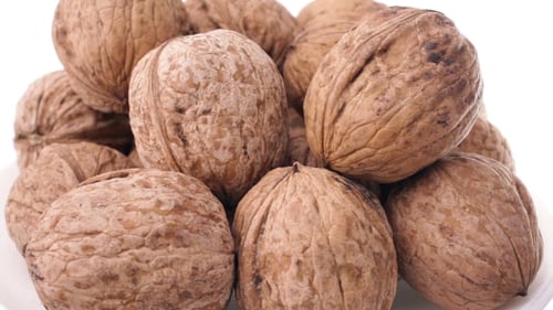 Pile of Whole Walnuts on White Surface