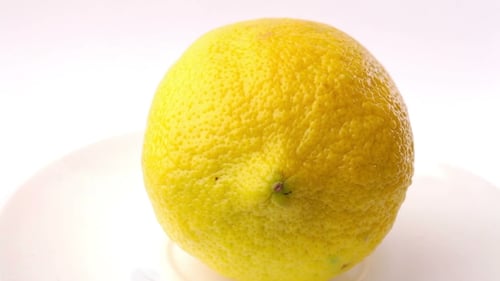 Yellow Lemon Turning On Itself On a White Background