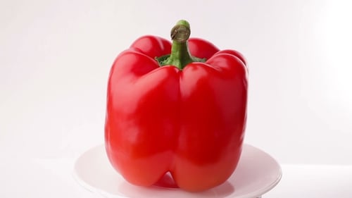 Red Bell Pepper Rotating on a White Plate