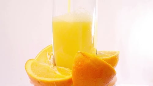 Orange Juice Poured into a Glass with Fruit