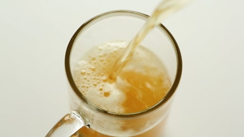 Beer Being Poured into a Clear Mug