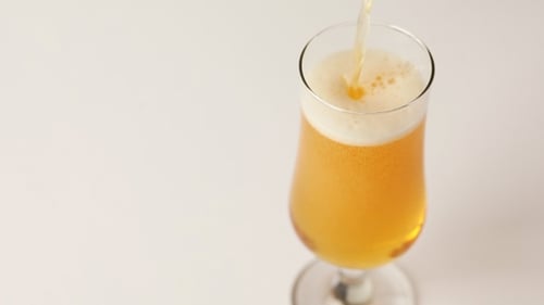 Light Beer Pouring into a Stemmed Glass