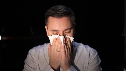 мужчина чихает