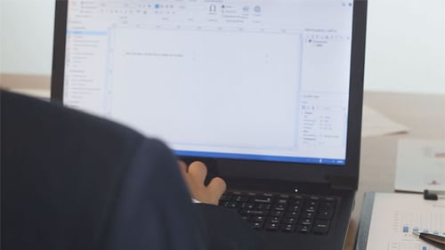 Man Typing on Laptop at Professional Workplace