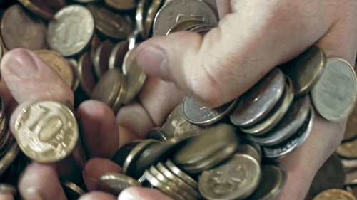 Close-up of Hands Shuffling Gold and Silver Coins