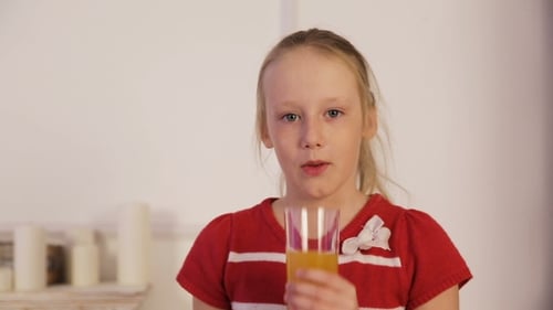 Young Girl Drinks Glass of Orange Juice