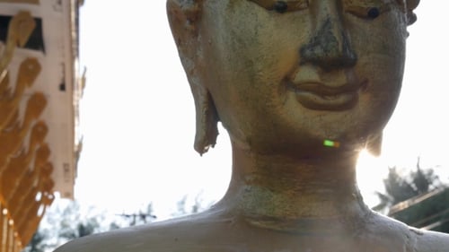 Face Of Golden Buddha Against Sunset In Temple