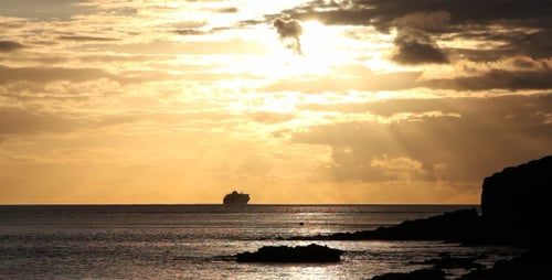 Sunset View with Ship on Ocean Horizon