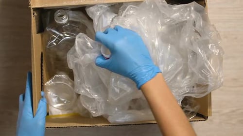 Sorting Plastic Trash in a Cardboard Box
