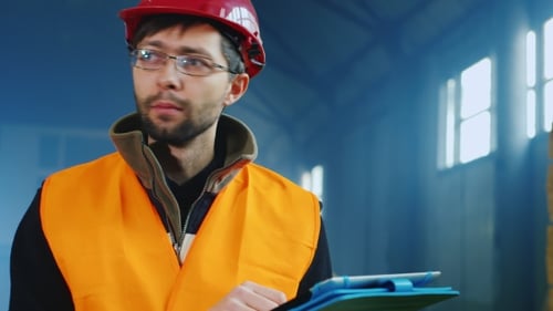Portrait Of a Warehouse Worker Or Builder, Who Works With The Tablet