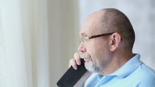 Man with Glasses Talking on Mobile Phone Indoors