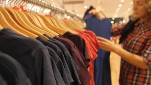 Young Woman Choosing Clothes In Shopping Mall