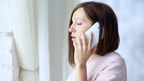 Woman Talking on Phone Indoors Near Window