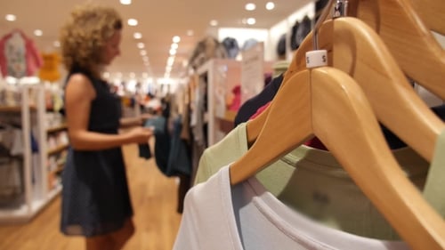 Woman Choosing Clothes In Shopping Mall
