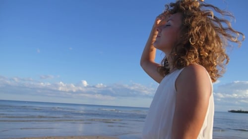 Mujer feliz caminando por la playa en vacaciones de verano