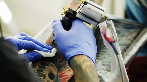 Tattoo Ink Rubs His Hand On The Client