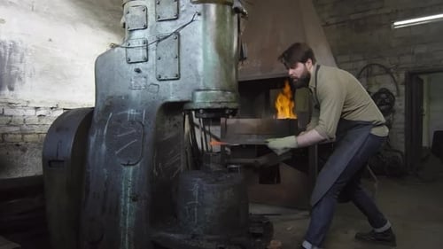 Blacksmith Forging Metal with Large Industrial Hammer