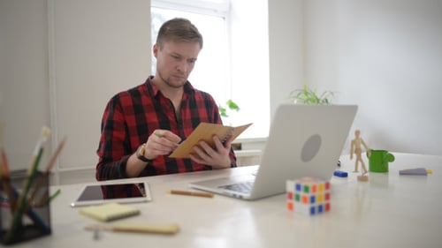 Young Designer Reading His Journal and Writing