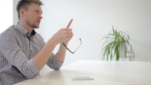 Young Adult Man with Glasses at Table