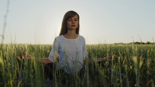 Woman Sits In Lotus Position Zen Gesturing At Sunset
