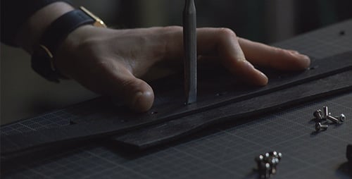 Artisan découpe des trous en utilisant un poinçon