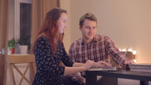 Young Adults Using Laptop in Warm Home Setting