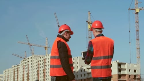Construction Workers Reviewing Plans at Construction Site