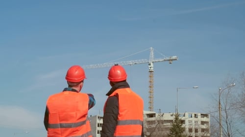 Construction Workers Reviewing Plans at Building Site