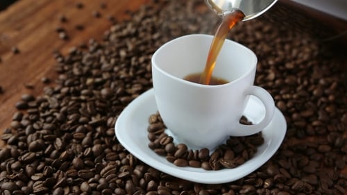Coffee Pouring Into White Cup on Bean Table