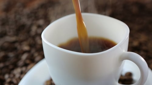 Coffee Pouring into Mug with Coffee Beans