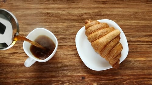 Coffee Pouring into White Mug with Croissant