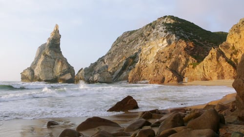 The Ocean Surf on an Empty Beach Between the Cliffs