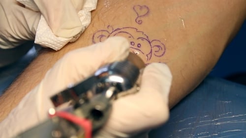 Tattoo Artist Inking a Monkey on Forearm