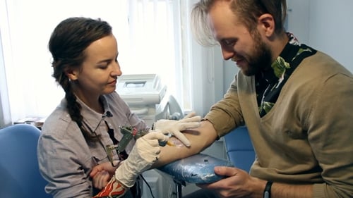 Woman Tattooing Man's Arm
