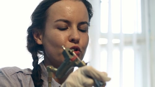 Tattoo Artist Working on Tattooing Machine