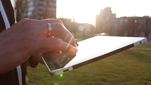Man Working on a Tablet on The Sunset Background