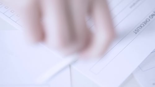Hand Completing Checklist Form in Bright Office