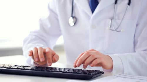 Männliche Arzthände tippen auf Tastatur 17