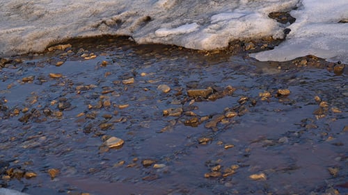 Stream Running Over Rocks During Winter Thaw