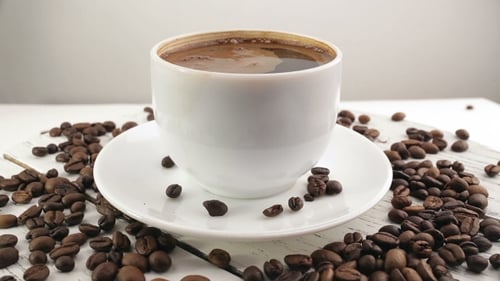 White Cup With Black, Hot Coffee Standing On Brown, Roasted Beans On Sacking