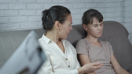 Woman Arguing with Teen Daughter Holding Smartphone