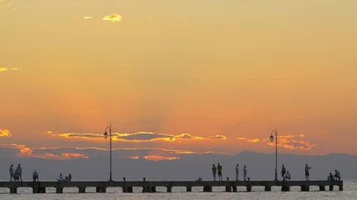 People Watching Sunset On Pier