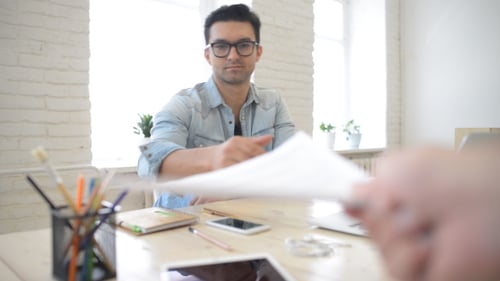 Young Professional Man Receiving Documents at Desk